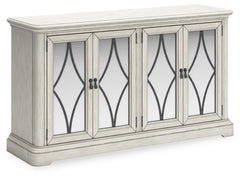 Add a touch of romance to your home with this dining server. The painted finish and shapely silhouette are all about easy elegance. This wide server turns the spotlight on antiqued mirrored doors with overlay fretwork, concealing plenty of storage while a
