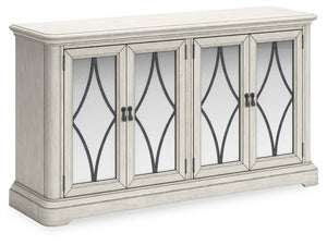 Add a touch of romance to your home with this dining server. The painted finish and shapely silhouette are all about easy elegance. This wide server turns the spotlight on antiqued mirrored doors with overlay fretwork, concealing plenty of storage while a
