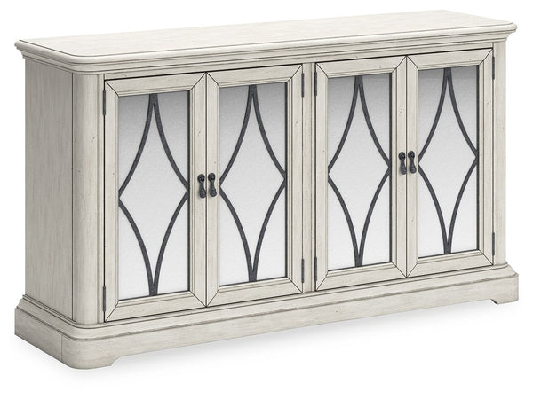 Add a touch of romance to your home with this dining server. The painted finish and shapely silhouette are all about easy elegance. This wide server turns the spotlight on antiqued mirrored doors with overlay fretwork, concealing plenty of storage while a
