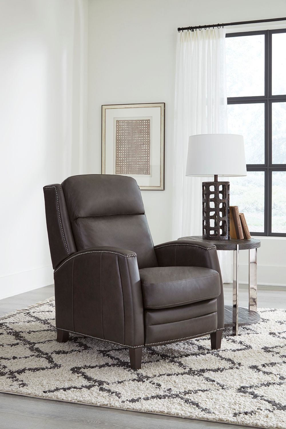 The Vermont power recliner offers a luxurious and effortless power pushback recline feature, allowing you to easily find the most comfortable position for relaxation. It is upholstered in soft leather with custom matching and features decorative nail head