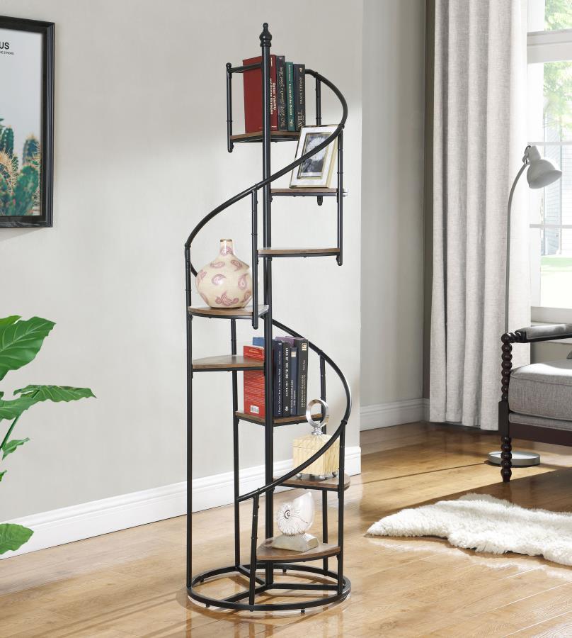 A unique black bookcase in a spiral design is sure to make your heart sing. Eight open shelves cascade down the frame of this rustic and industrial piece. The frame is crafted from metal with a black finish. The triangular shelves are finished in a warm w