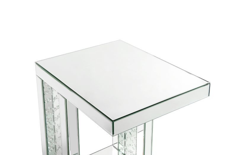 Go full glam with this Nysa Accent Table. The clear mirrored table top and glistening faux crystals inlay will reflect light and make any room appear larger. It provides a spacious table top ample enough for displaying various decor items while the unique