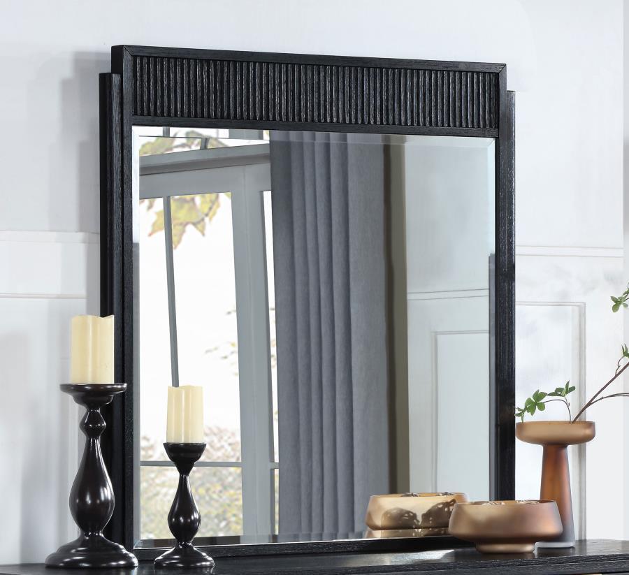 Complete your dresser with a stylish framed mirror. A perfect complement, it features a wooden frame complete with a fluted panel on top that adds rich depth and dimension. The mirror features a black finish with wire brushing that creates textural flair.