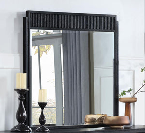 it features a wooden frame complete with a fluted panel on top that adds rich depth and dimension. The mirror features a black finish with wire brushing that creates textural flair.