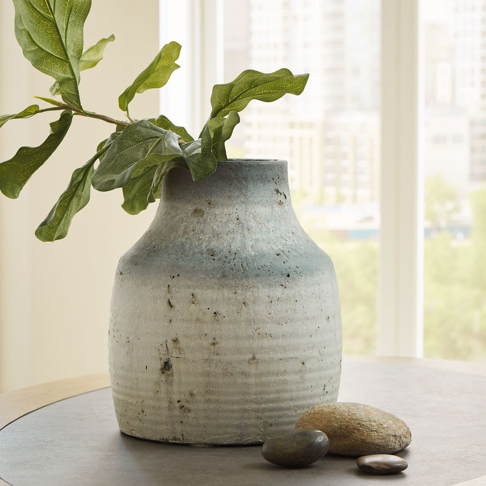 This vase has a weathered aesthetic that adds a culturally sophisticated look to your decor. Display the piece on a table or countertop where its artistry can be appreciated.<br/><br/><b>Product Features</b><ul><li>Made of cement</li><li>Black and gray di