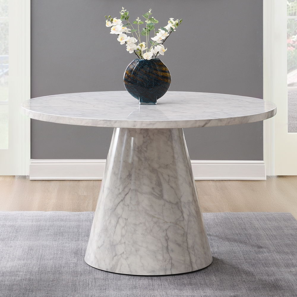 The Kacey dining set, with its elegant round wooden table top, exudes charm and sophistication. The marble grain finish adds a touch of luxury, while the single pedestal base ensures stability. Complemented by padded seat and back cushion side chairs, thi