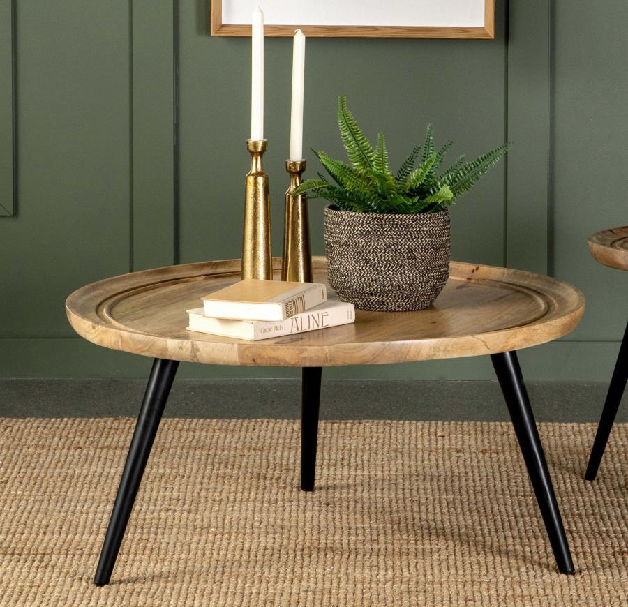 This round coffee table merges mid-century charm with rustic appeal for a timeless addition to your living room. Crafted from solid mango wood with a natural finish, it showcases unique wood grain patterns and a softly beveled edge for a subtle dish-like 