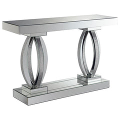 This mirrored console table features an elegant design with a rectangular top and bold, oval-shaped bases. The base is adorned with acrylic crystals, adding a luxurious and glamorous touch to its modern aesthetic. Crafted with mirrored surfaces, this tabl