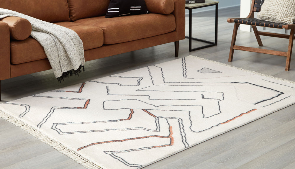 In a mesh of neutral tones, this accent rug features a modern abstract design that will warm your living space. Freeform lines with a knotted tassel edge elevate the look, and the medium pile height adds just the right amount of cushion underfoot. And it-