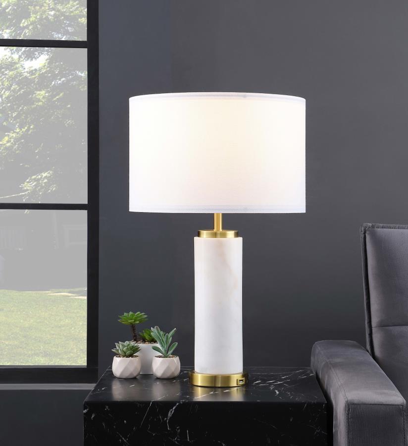 Classic luxury meets modern in a charming table lamp built for a sophisticated living space. A white marble column centers the lamp, offering luxe energy and appeal in any setting, from a nightstand to a server and beyond. Soft gold accents enhance the la