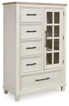 This door chest elevates the art of modern farmhouse design. Its two-tone aesthetic blends antiqued white and light grayish brown for a charming finish. Framed drawer fronts and a windowpane door lend a country feel. Conveying a feeling of relaxed comfort