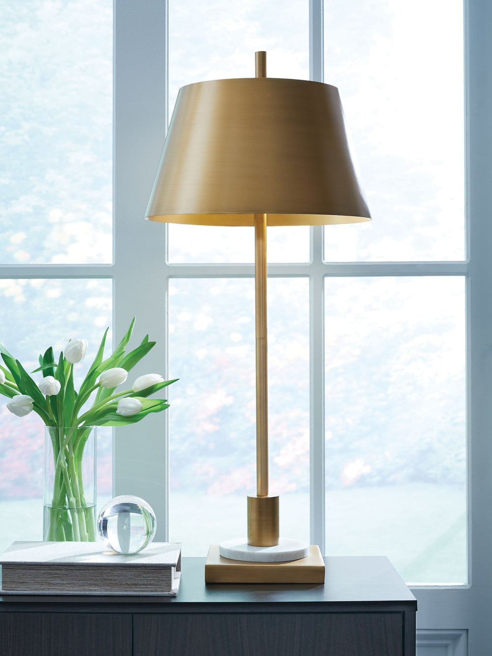 Sleek and glamourous, this contemporary table lamp shines the spotlight on modern luxury. Its rich goldtone finish, elongated body and white marble accent are utterly elegant. A luxe addition to an office desk or bedside table, itâ€™s topped with a gleami