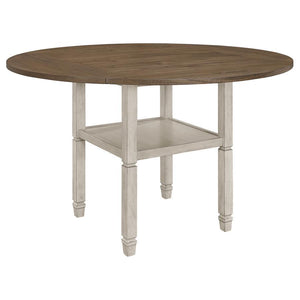 Uniquely fashionable and supremely functional, this counter height dining table has it all. Perfect for spontaneously switching up your style, the square tabletop features four drop down leaves to convert it to a round shape. An open shelf is built into t