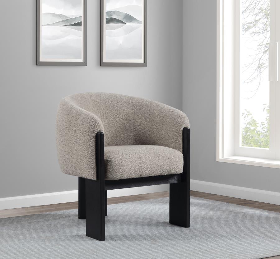 Bring updated style and sophistication to your living room or den with a modern accent armchair. It boasts an inviting rounded silhouette with sloping arms. Three legs in a black finish add a sculptural sensibility. Textured boucle upholstery creates rich