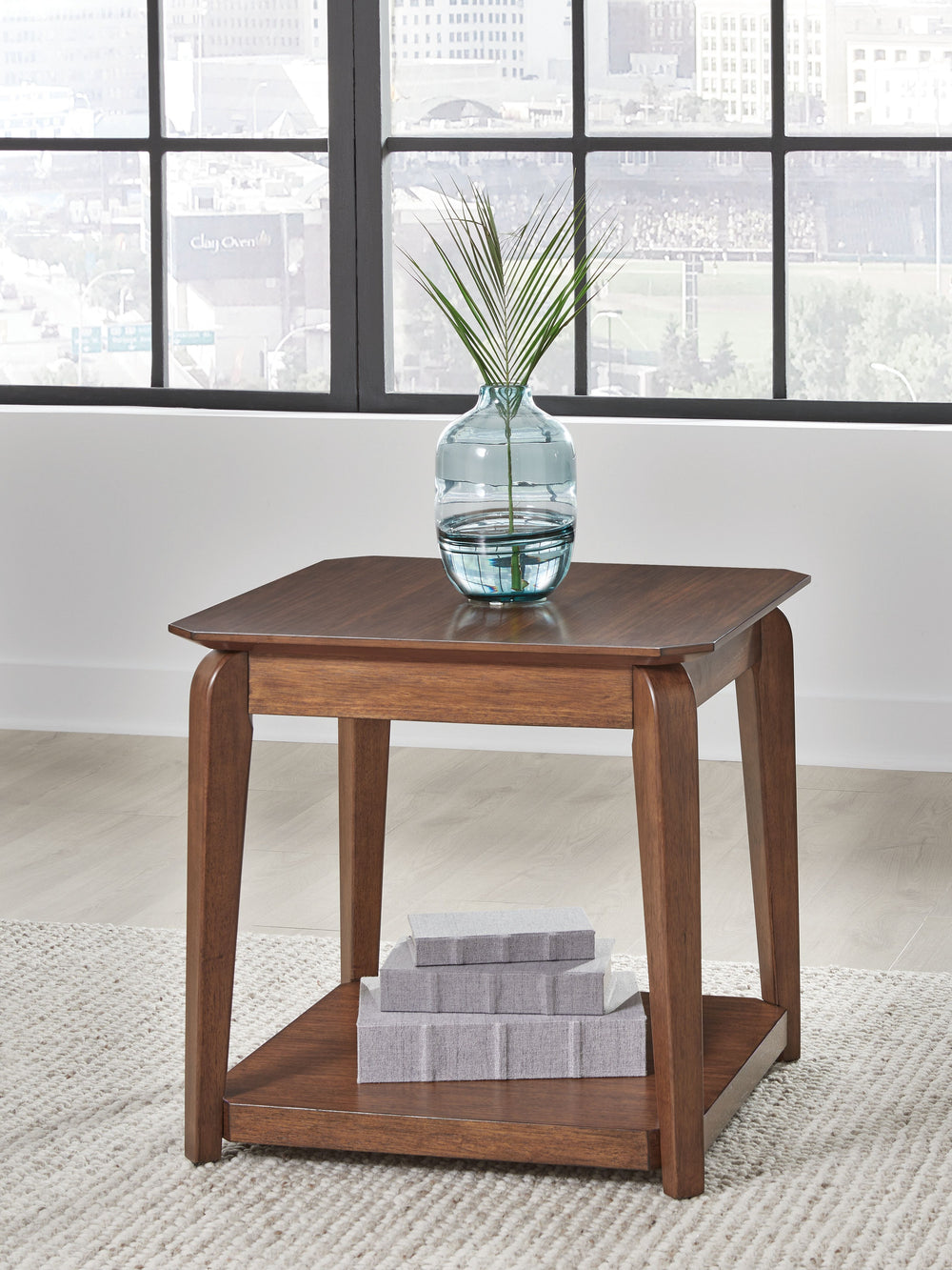 Create retro-inspired character in your living room with this end table. Warm and welcoming in a medium brown, its softly rounded top and tapered legs offer a mid-century appeal well-suited to styles from modern to eclectic. And with a lower shelf for dis