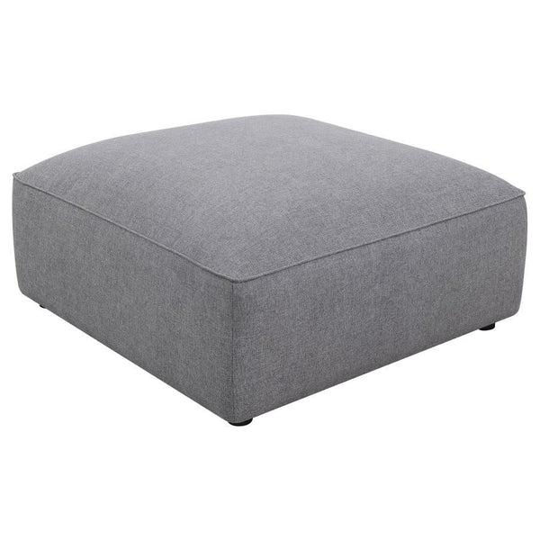 The minimalist design and sophisticated tailored look elevate this contemporary grey ottoman. The large, oversized, boxy shape is upholstered in a soft grey woven fabric that lends it a hint of texture. With a neutral monochromatic color palette, this ott