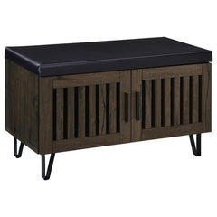 This modern storage bench combines style and functionality, featuring a faux leather upholstered padded top for added versatility as a seating bench. The cabinetâ€™s two doors showcase a vertical slat design, enhancing its contemporary aesthetic while all