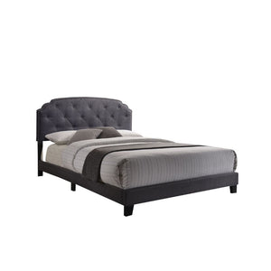 The Tradilla queen bed is a platform style bed featuring padded fabric on the headboard, footboard and side rails. It is supported by wood feet and wood headboard posts. The headboard features Nailhead trim bordering an interesting traditional top shape, 