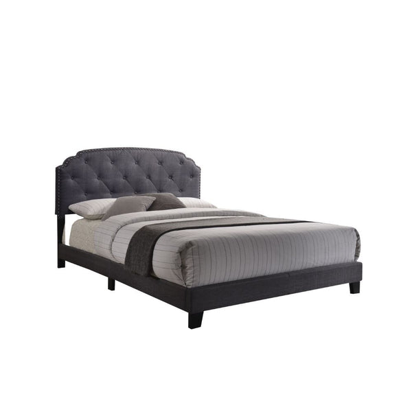 The Tradilla queen bed is a platform style bed featuring padded fabric on the headboard, footboard and side rails. It is supported by wood feet and wood headboard posts. The headboard features Nailhead trim bordering an interesting traditional top shape, 