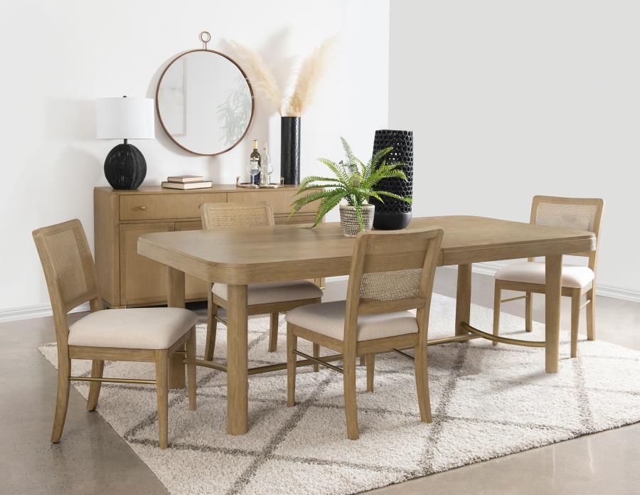 This dining set blends modern craftsmanship with natural textures for a refined yet inviting feel. The dining table features a trestle base with an antique brass-finished metal stretcher bar, adding stability and contrast. Rounded corners soften the recta