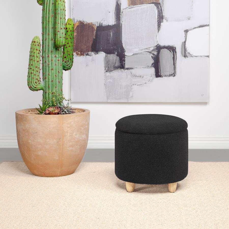 Nestled atop subtle, natural brown rounded wood feet, this round storage ottoman is a stylish statement of comfort and practicality. Upholstered in a soft faux sheepskin, it beckons with tactile appeal, inviting a moment of relaxation. The removable top u