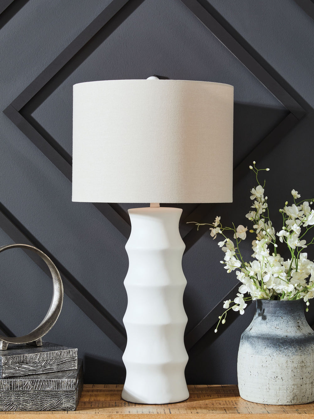 Add flair to your lair with this striking table lamp. With a distinctive scalloped design and a fresh white finish, itâ€™s cool from every angle. And its versatile style looks right at home everywhere from contemporary places to casual spaces. The matchin