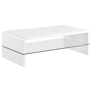 This ultra-modern coffee table showcases a sleek, high-gloss white finish and clean lines. Its rectangular tabletop flows seamlessly into waterfall edges, creating a contemporary silhouette. A clear tempered glass shelf offers an airy, open feel while pro