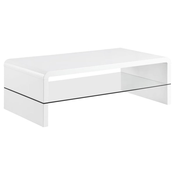 This ultra-modern coffee table showcases a sleek, high-gloss white finish and clean lines. Its rectangular tabletop flows seamlessly into waterfall edges, creating a contemporary silhouette. A clear tempered glass shelf offers an airy, open feel while pro