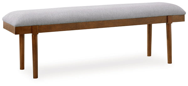 A refreshed take on retro aesthetics. This upholstered bench adds an air of simplicity to your dining space, capturing the architectural language of mid-century stylings. Its seat invites the eye with a soft-edged silhouette and neutral gray cushion. A ca
