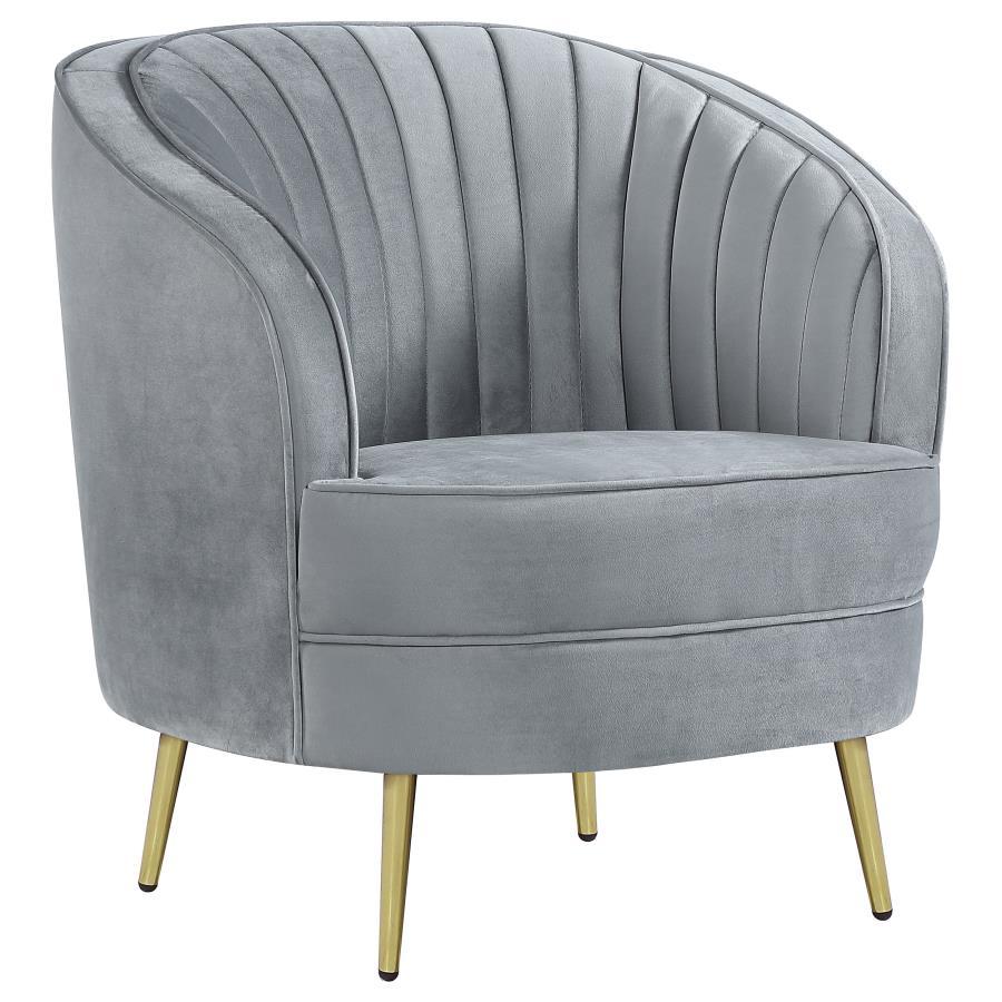 Add a touch of retro-inspired glamour to your space with this elegant accent chair in soft grey velvet. The curved barrel design and channeled backrest create a stylish focal point, while plush cushioning and gold tapered legs provide comfort and modern s