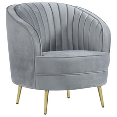 Add a touch of retro-inspired glamour to your space with this elegant accent chair in soft grey velvet. The curved barrel design and channeled backrest create a stylish focal point, while plush cushioning and gold tapered legs provide comfort and modern s