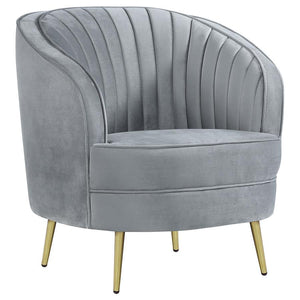 Add a touch of retro-inspired glamour to your space with this elegant accent chair in soft grey velvet. The curved barrel design and channeled backrest create a stylish focal point, while plush cushioning and gold tapered legs provide comfort and modern s