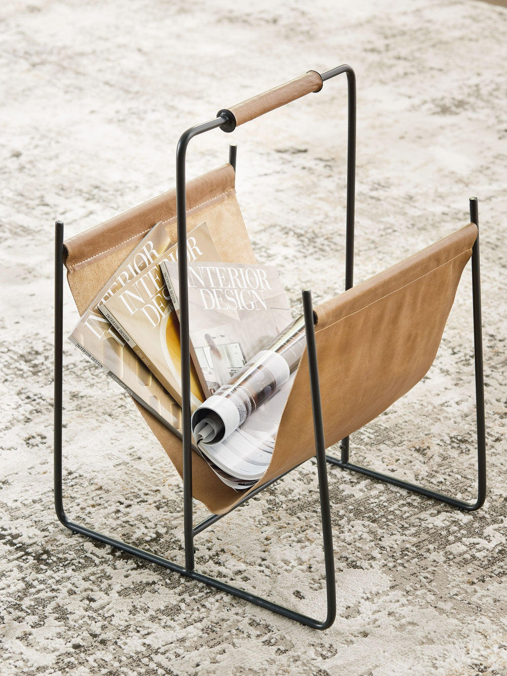 Periodicals piling up? Keep every magazine and catalog effortlessly corralled with this magazine rack. Classic brown leather and a complementary black frame combine sleek style with functional storage. Whether this piece is holding your favorite reads or 