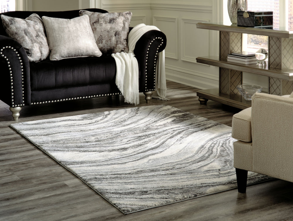 Inspired by gorgeous quartz bands of agate, this area rug displays flowing ribbons of color. Its machine-woven high-low agate design, in ivory and shades of gray, features deep, rich hues while maintaining exceptional durability. Comfortable and sophistic