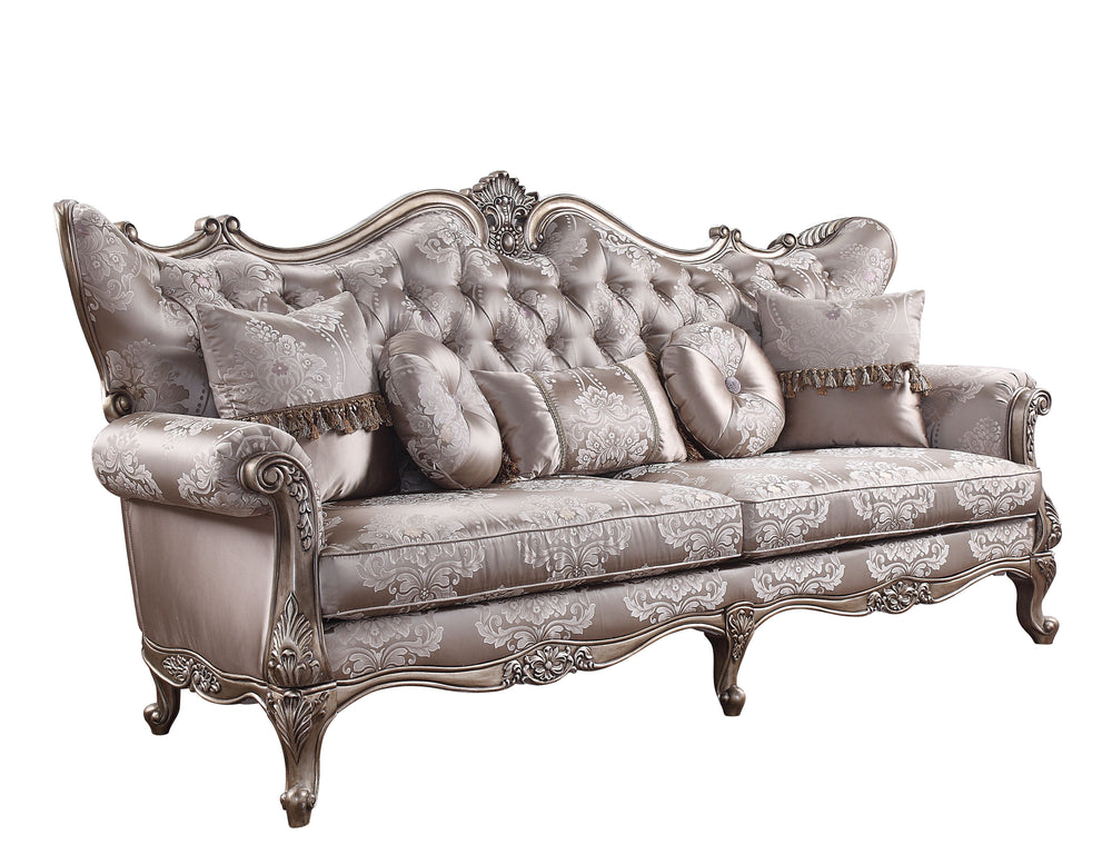 The Jayceon sofa collection is gorgeous, with shimmery fabric upholstery that highlights the champagne finish of the wooden frame. Button-tufted seatbacks wing out under carved arches. Loose seat cushions are upholstered in a floral patterned fabric that 