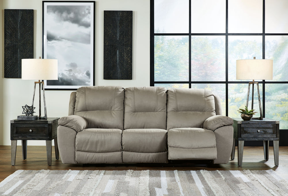 Kick back, relax, and enjoy some sports on TV with this reclining sofa. You will love its double stuffed pillow top arms and soft-as-suede faux leather upholstery. The family-friendly dark gray color and creative stitching add panache. Recline in comfort 