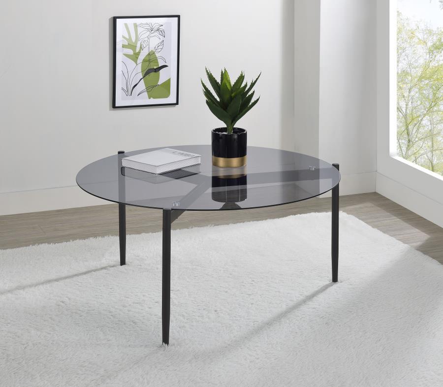 This modern coffee table features a sleek, tempered smoked glass top that adds sophistication to any space. Its sturdy metal base, finished in a black powder-coated sandy texture, provides stability and a contemporary edge. The round design creates a welc