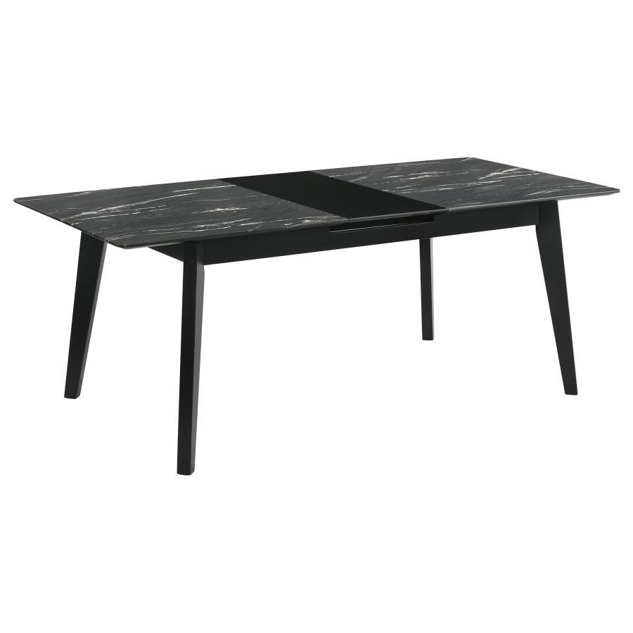 The luxurious look of faux marble creates a glam sensibility for a modern dining table. The black marble look of the tabletop complements a sleek base with fin-style legs and a recessed apron. The table includes a self-storing leaf for easy expansion to a
