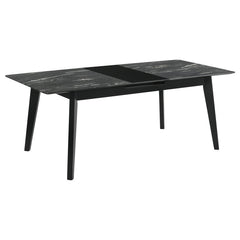 The luxurious look of faux marble creates a glam sensibility for a modern dining table. The black marble look of the tabletop complements a sleek base with fin-style legs and a recessed apron. The table includes a self-storing leaf for easy expansion to a