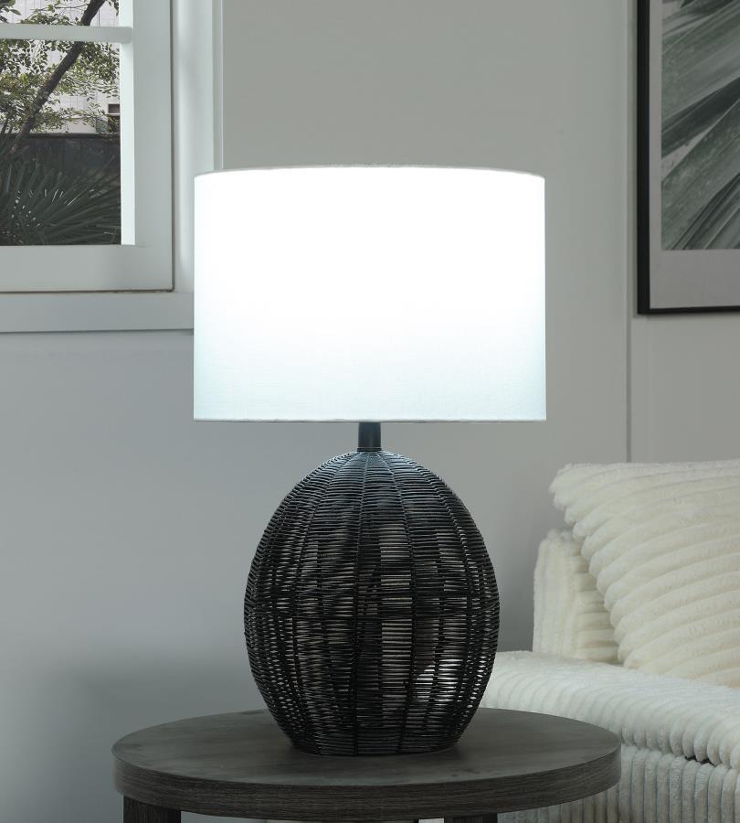 This table lamp combines natural textures with modern craftsmanship, featuring a rounded black rattan base that adds visual intrigue. Paired with a sturdy metal frame for durability and a neutral fabric shade for soft, even lighting, it offers both style 