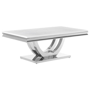 This coffee table showcases modern glam with a sintered stone top, featuring a marble-like appearance and beveled edges. Its sweeping demilune pedestal base, crafted from polished stainless steel, combines sculptural elegance with durable construction. Th