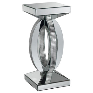 This chic and contemporary end table captivates with its sculptural, artistic design. Crafted with mirrored surfaces and engineered wood, it exudes modern luxury. The intersecting oval-shaped loops form a striking, three-dimensional silhouette, enhanced b