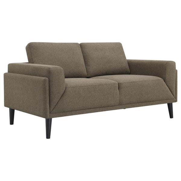 Unveiling our modern loveseat, where innovation meets elegance in a frame within a frame design. Adorned in a chic fabric, its streamlined silhouette is highlighted by meticulous topstitch details and track arms complemented by mitered front accents. Prio