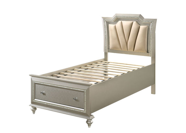 The Kaitlyn bed provides a commanding presence in any master bedroom. This contemporary storage bed in champagne finish features a diagonal channeled tufted padded headboard and a low-profile footboard with storage drawers. Expertly crafted with a glam lo