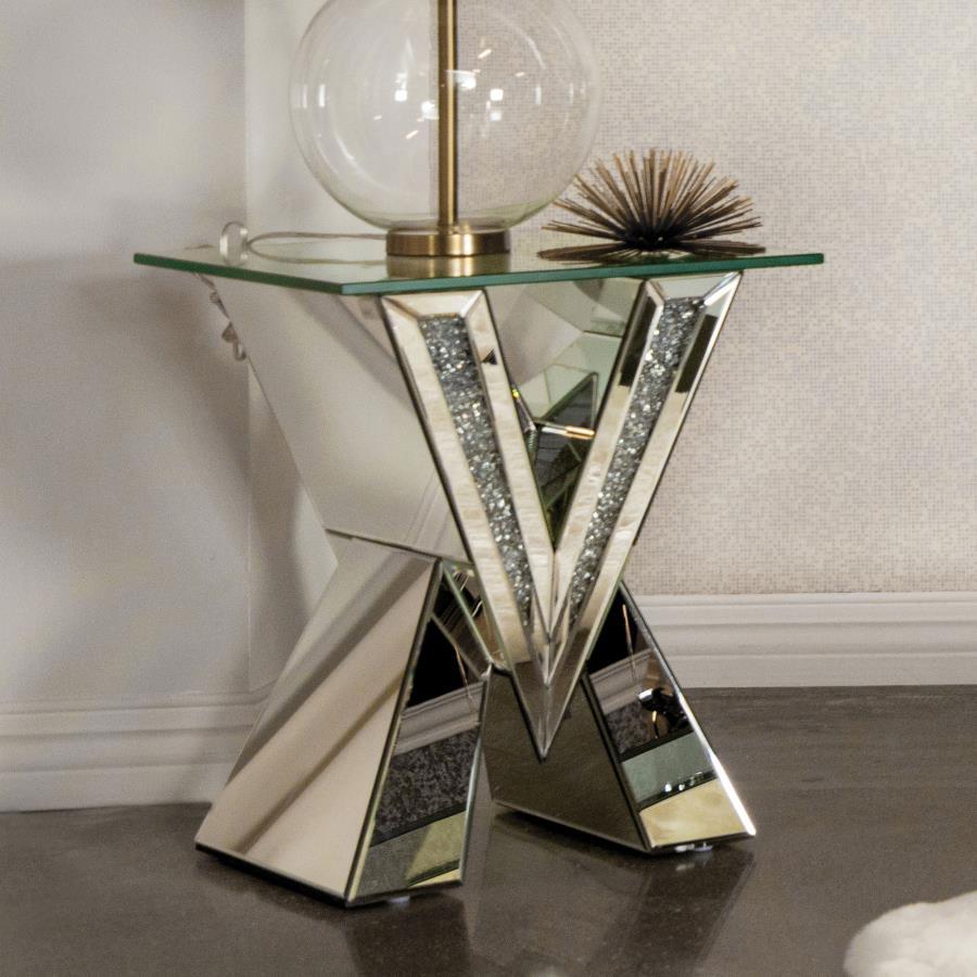 This mirrored end table brings a bold, artistic flair to any living space. Its striking V-shaped base features mirrored panels and glittering crystal accents, creating a glamorous and reflective design. Topped with a square, beveled tempered glass surface