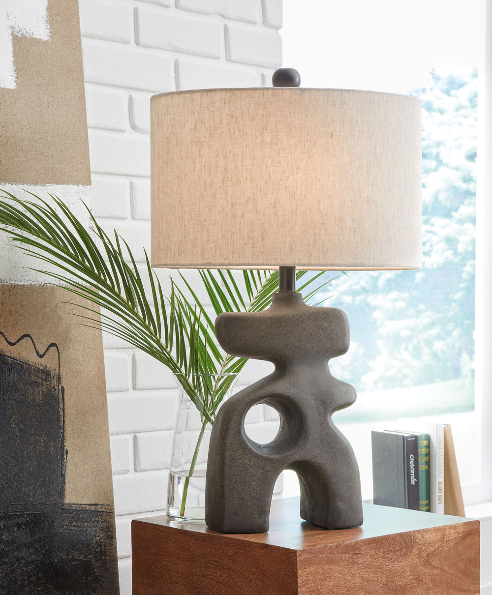 This striking table lamp is an enlightening choice for those with an eye for contemporary design. A free-flowing base and sleek oval shade elevate this piece to a simply illuminating art form. Place it anywhere you need an infusion of sophisticated style.