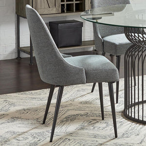  wrapped in soft textured grey fabric. Its sleek wingback-inspired profile and gently tapered gunmetal legs bring a fresh