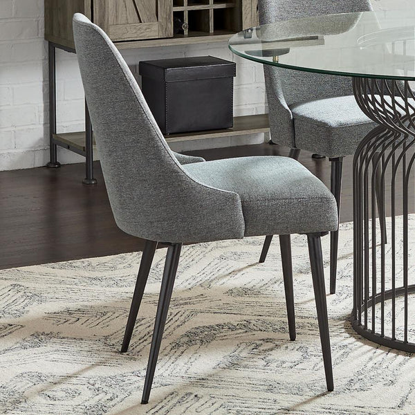  wrapped in soft textured grey fabric. Its sleek wingback-inspired profile and gently tapered gunmetal legs bring a fresh