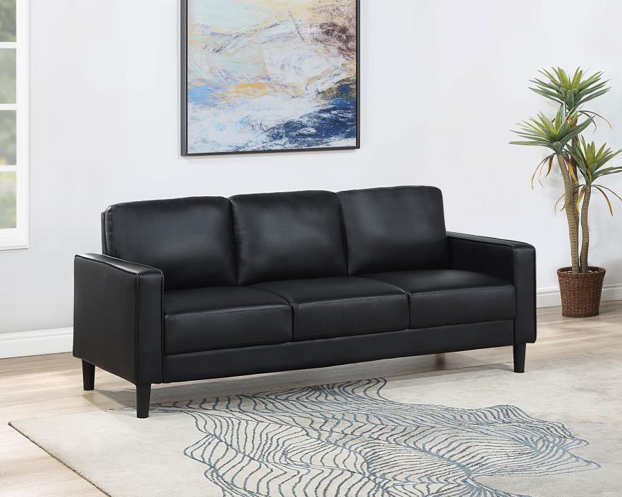 Establish the foundation of a stylish living room with a modern sofa. Smooth faux leather creates a sleek, neutral look that brims with sophistication. Track arms create a structured silhouette, offering tailored flair with an understated ambiance. Straig