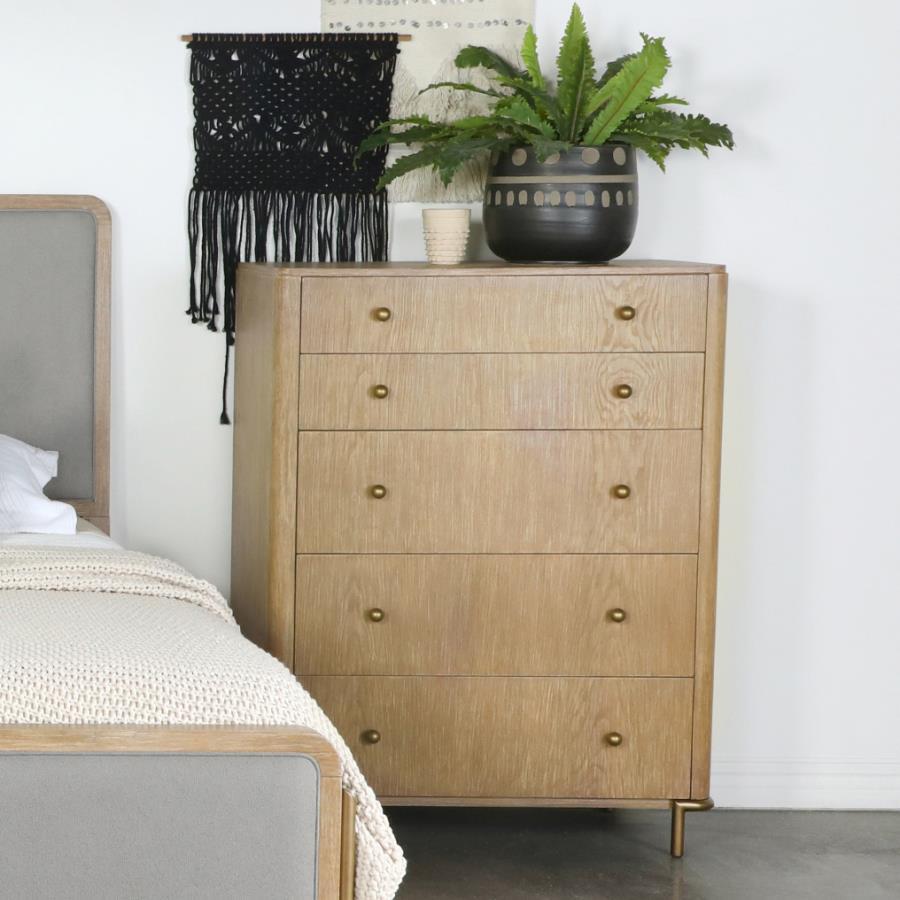 This charming mid-century, modern, five-drawer chest offers a gorgeous contemporary glam look with its softly rounded corners and aged brass metal hardware. A neutral sand wash wood tone with a wire-brushed finish adds texture and warmth to bedrooms. Clev